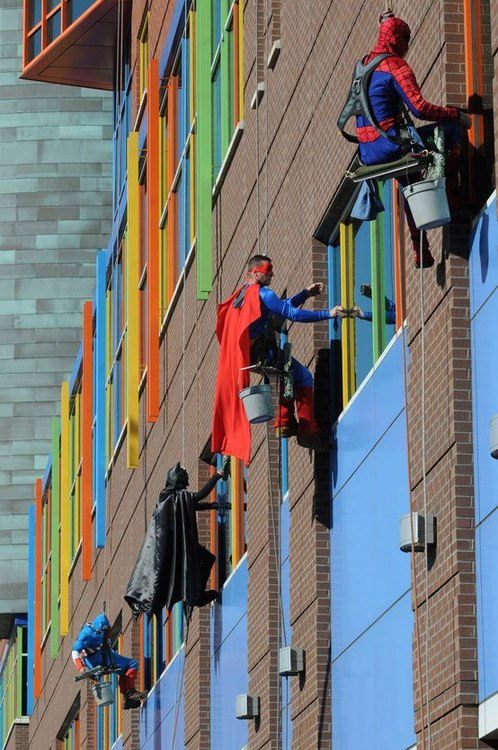 superheroes limpian ventanas de hospital