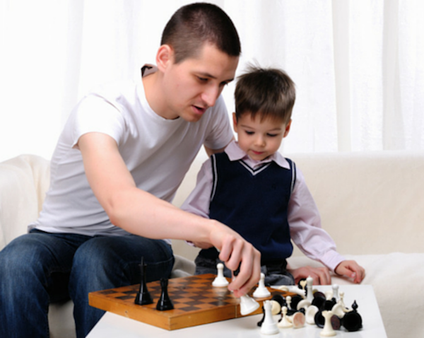padre jugando ajedrez con su hijo
