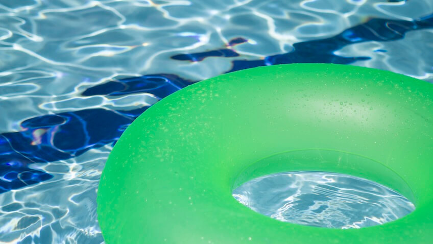 flotador verde en piscina verano