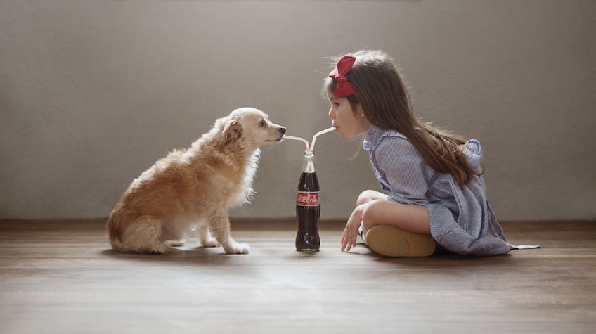 niña y perro con coca cola